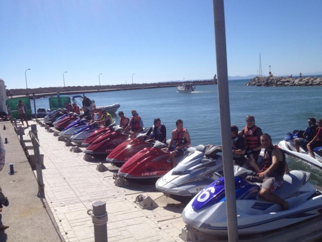 grupo de chicos montados en motos de aguas amarradas